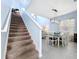 Bright dining room off stairs featuring modern light fixture, table for six, and large window at 13304 Mandalay Pl, Spring Hill, FL 34609