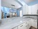 Bright, airy kitchen with white cabinetry, marble countertops, and an open view to the dining room at 13304 Mandalay Pl, Spring Hill, FL 34609