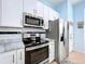 Modern kitchen features stainless steel appliances, marble countertops, and white shaker cabinets at 13304 Mandalay Pl, Spring Hill, FL 34609
