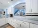 Contemporary kitchen showcasing white cabinets, marble countertops, and stainless steel appliances at 13304 Mandalay Pl, Spring Hill, FL 34609