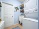 Efficient laundry room with stackable washer/dryer, shelving, storage baskets, and blue accent rug at 13304 Mandalay Pl, Spring Hill, FL 34609