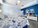 Bright bedroom highlighting a unique blue accent wall, plush carpeting, and well-placed shelving at 13304 Mandalay Pl, Spring Hill, FL 34609