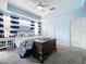 Inviting bedroom featuring a neutral color scheme, carpet, and a tray ceiling at 13304 Mandalay Pl, Spring Hill, FL 34609
