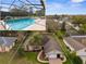 Inviting single-story home showcasing a screened pool and well-maintained lawn with mature landscaping and a brick driveway at 1382 Aladdin Rd, Spring Hill, FL 34609