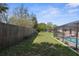 Spacious backyard with wood fence and view of the screened-in pool area at 1382 Aladdin Rd, Spring Hill, FL 34609