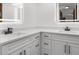 Modern bathroom vanity with dual sinks, sleek countertops, and ample storage space in white cabinets with black hardware at 1382 Aladdin Rd, Spring Hill, FL 34609