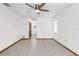 Minimalist bedroom showing neutral walls, tile flooring, two windows with blinds, ceiling fan, and closet at 1382 Aladdin Rd, Spring Hill, FL 34609