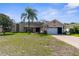 Charming home featuring a well-manicured lawn, palm tree, brick driveway, and an attached two-car garage at 1382 Aladdin Rd, Spring Hill, FL 34609