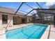 The screened-in pool area features a brick surround and ample space for entertaining next to the home's exterior patio at 1382 Aladdin Rd, Spring Hill, FL 34609