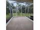 The screened-in patio features views of the grassy backyard and a white picket fence at 15772 Stable Run Dr, Spring Hill, FL 34610