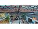 View from above of the atrium with a wooden deck, skylights, diverse plants, and decorative fountain at 17932 Wendy Sue Ave, Hudson, FL 34667