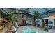 Unique sunroom with a wooden deck, skylights, diverse plants, and decorative fountain at 17932 Wendy Sue Ave, Hudson, FL 34667