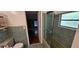 A vintage bathroom with green tile walls and a glass shower door at 17932 Wendy Sue Ave, Hudson, FL 34667