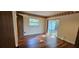 Cozy bedroom featuring hardwood floors, large windows, and an access door to outside at 17932 Wendy Sue Ave, Hudson, FL 34667