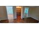 Bedroom features parquet floors, pale blue walls, a closet with shelves, and backyard views at 17932 Wendy Sue Ave, Hudson, FL 34667