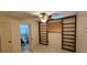 Bedroom featuring built-in shelves, a ceiling fan, and an attached bathroom at 17932 Wendy Sue Ave, Hudson, FL 34667