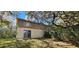 A tan two-story home with a sliding door and several windows is set against a backdrop of lush greenery and trees at 17932 Wendy Sue Ave, Hudson, FL 34667