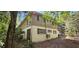 View of the rear exterior highlighting the home's light siding, surrounded by a green landscape with small trees at 17932 Wendy Sue Ave, Hudson, FL 34667
