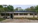 A single-story home with mature trees, a dark roof, and a large front yard at 17932 Wendy Sue Ave, Hudson, FL 34667