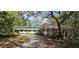 Expansive property featuring a covered outdoor space, mature trees, and a long driveway at 17932 Wendy Sue Ave, Hudson, FL 34667
