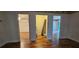 Hallway with hardwood floors leading to a bedroom, laundry area, and another room at 17932 Wendy Sue Ave, Hudson, FL 34667