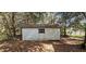 Exterior view of storage shed with horizontal siding and a small window, set among trees at 17932 Wendy Sue Ave, Hudson, FL 34667