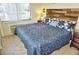 Cozy bedroom featuring a rustic wooden headboard, patterned bedding, and lots of light at 20857 Haulover Cv # B15, Lutz, FL 33558