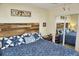 Inviting bedroom featuring a rustic wooden headboard, patterned bedding and mirrored closet at 20857 Haulover Cv # B15, Lutz, FL 33558