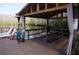 Lakeside cabana offers comfortable seating, a table, and scenic views for relaxation and entertainment at 20857 Haulover Cv # B15, Lutz, FL 33558