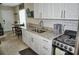Well-lit kitchen with white cabinets, granite countertops and modern appliances and dining table at 20857 Haulover Cv # B15, Lutz, FL 33558