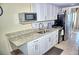 Compact kitchen with granite countertops and stainless steel appliances at 20857 Haulover Cv # 15, Lutz, FL 33558