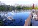 Scenic lake with calm waters, trees reflecting off the water, with the community dock in the distance at 20857 Haulover Cv # B15, Lutz, FL 33558