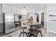 Charming kitchen boasts a stainless steel refrigerator, granite countertops, and round dining table at 291 115Th Ave, Treasure Island, FL 33706