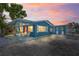 Attractive blue single-story home featuring covered parking, outdoor seating, and well-maintained exterior at 291 115Th Ave, Treasure Island, FL 33706