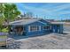 Charming blue single-story home boasts covered parking, outdoor seating, and a spacious driveway at 291 115Th Ave, Treasure Island, FL 33706