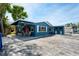 Charming blue home with covered patio, red door, and adjacent laundry room at 291 115Th Ave, Treasure Island, FL 33706