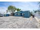Exterior side view of a blue home with ample parking space and privacy fence at 291 115Th Ave, Treasure Island, FL 33706