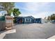 Charming blue home featuring white shutters, a small porch, and ample parking space in front at 291 115Th Ave, Treasure Island, FL 33706