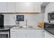 Bright kitchen featuring white cabinets, granite countertops, stainless steel appliances, and modern fixtures at 291 115Th Ave, Treasure Island, FL 33706