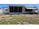 Exterior home view showing the backyard with grass and a screened-in porch at 3243 Bayport Dr, Holiday, FL 34691