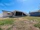 View of backyard, detached garage, screened-in porch, and clear blue sky at 3243 Bayport Dr, Holiday, FL 34691