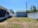 Backyard view featuring a detached garage, screened-in porch and a clear blue sky above at 3243 Bayport Dr, Holiday, FL 34691