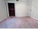 Bedroom with mauve carpet, light walls, and a walk-in closet with wood paneling for ample storage at 3243 Bayport Dr, Holiday, FL 34691