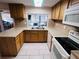 Bright kitchen featuring modern appliances, wood cabinetry, tile floors, and stone countertops at 3243 Bayport Dr, Holiday, FL 34691