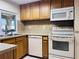 Bright kitchen featuring modern appliances, wood cabinetry, tile floors, and stone countertops at 3243 Bayport Dr, Holiday, FL 34691