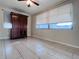Living room featuring tile floors, a ceiling fan, and a dark wood entertainment center at 3243 Bayport Dr, Holiday, FL 34691