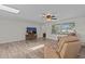 Bright living room with tile flooring, ceiling fan, and a large window for natural light at 3328 Gulfview Dr, Hernando Beach, FL 34607