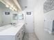 Modern bathroom featuring a large mirror, decorative lighting, white cabinets and hardware at 3344 Gardenia Dr, Hernando Beach, FL 34607