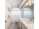 Well-lit bathroom featuring white cabinets, a large mirror, shower with curtains, and gray tile flooring at 3344 Gardenia Dr, Hernando Beach, FL 34607
