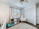 Bedroom featuring a rocking chair, crib, and closet with folding doors at 3344 Gardenia Dr, Hernando Beach, FL 34607